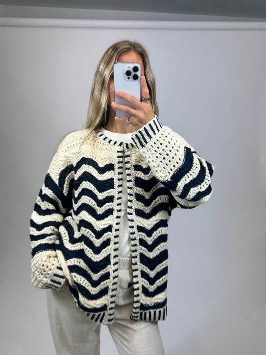Person wearing a black and white striped sweater against a plain background